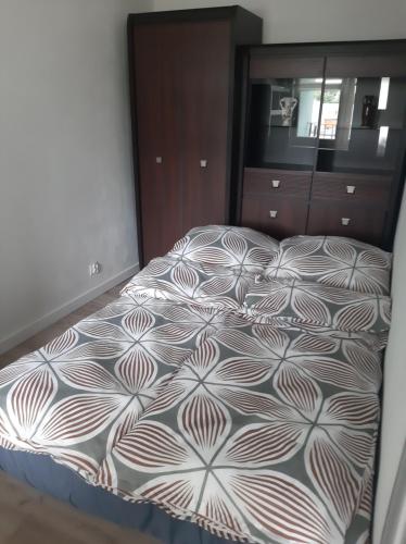 duże łóżko w sypialni z komodą w obiekcie Apartament Komfortowy - w pełni wyposażony - SpaceApart w Jeleniej Górze