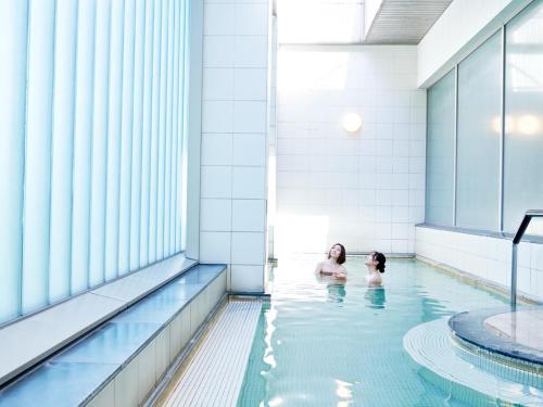 un hombre y un niño en una piscina en Sapporo Prince Hotel, en Sapporo