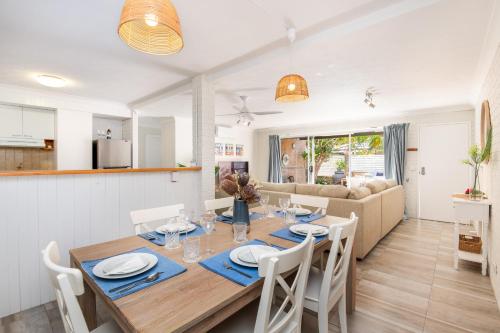 a dining room and living room with a table and chairs at Sawtell Beachfront Villa - 2 mins to everything! in Sawtell
