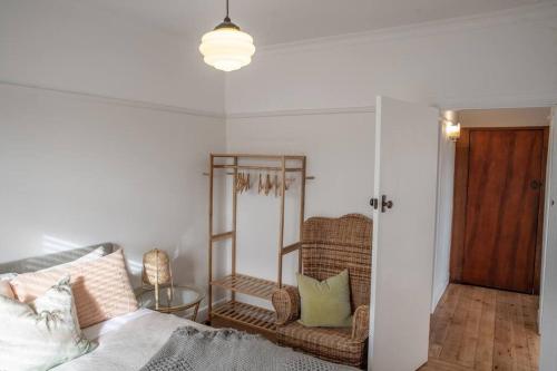 a living room with a bed and a chair at Barkly Beach House Warrnambool in Warrnambool