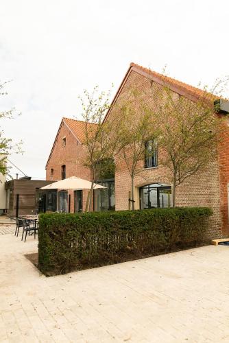 a brick building with a hedge in front of it at HVN10 - Near Antwerp in Stabroek