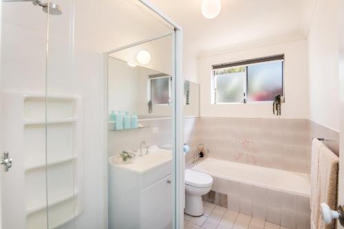 a bathroom with a tub and a toilet and a sink at Sawtell Beachfront Villa - 2 mins to everything! in Sawtell