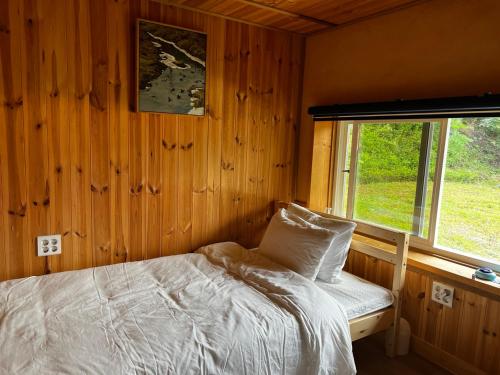 Schlafzimmer mit einem Bett und einem Fenster in der Unterkunft Chef's Garden 