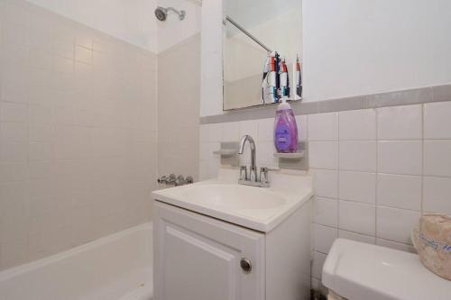 a white bathroom with a sink and a bath tub at Studio close to Times Square in New York