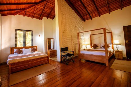 a bedroom with two beds and a chair in it at Benjamin Cottage Haputale in Haputale