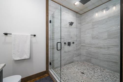 a shower with a glass door in a bathroom at Peaceful Luxury Cabin, hot tub, games, 3 fireplaces in Blue Ridge
