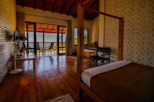 a bedroom with a bed and a table and chairs at Benjamin Cottage Haputale in Haputale