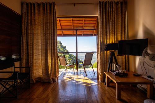 a living room with a large window with a view at Benjamin Cottage Haputale in Haputale