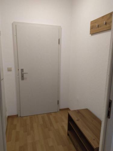 a room with a white door and a wooden table at Apartment für Monteure in Sandersdorf in Sandersdorf