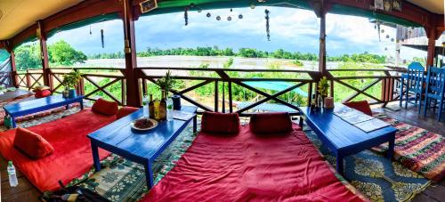 a room with two blue tables and a view of a field at Don Det Sokxay and Mamapieng Budget Guesthouse in Don Det