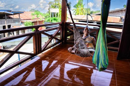 - un homme assis sur une terrasse couverte avec un hamac dans l'établissement Don Det Sokxay and Mamapieng Budget Guesthouse, à Don Det