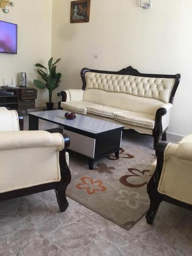 a living room with couches and a coffee table at Mountainview house#122 in Kisumu