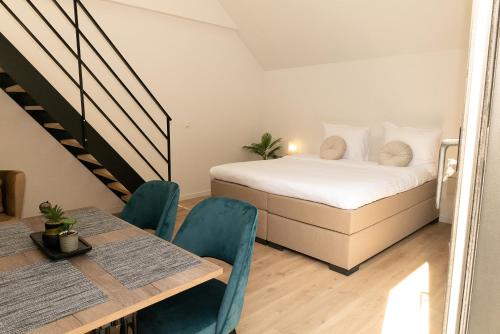 a bedroom with a bed and a table and chairs at HVN10 - Near Antwerp in Stabroek
