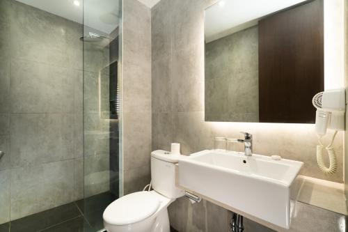 a bathroom with a toilet and a sink and a mirror at Swiss-Belinn Bogor in Bogor