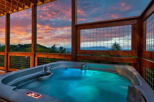 a jacuzzi tub in a room with a view at New Luxury Cabin with Stunning MountainVIEWS,HotTub, FirePit, FirePlace,2 KingBeds, 2 CoveredDecks,BBqGrill, ShuffleBoard and Pool Access in Sevierville