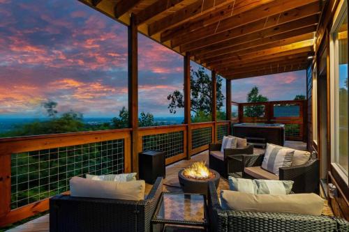 a room with chairs and a fireplace on a balcony at New Luxury Cabin with Stunning MountainVIEWS,HotTub, FirePit, FirePlace,2 KingBeds, 2 CoveredDecks,BBqGrill, ShuffleBoard and Pool Access in Sevierville