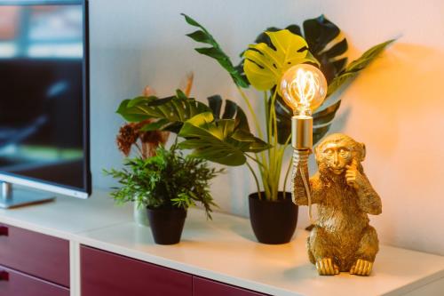 a lamp on a desk with plants and a statue at Dschungel in BaLi 72qm Ferienwohnung im Zentrum in Bad Lippspringe