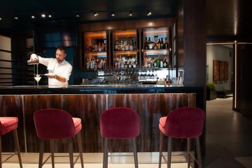 a man standing at a bar holding a wine glass at Matrix Hotel in Edmonton