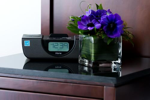 a clock sitting next to a vase of purple flowers at Matrix Hotel in Edmonton