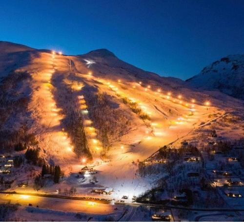 a snow covered hill with lights on it at night at Fjord peace in Skodje