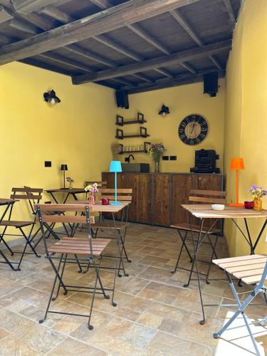 a room with tables and chairs and a clock on the wall at Domo Achenza in Terralba