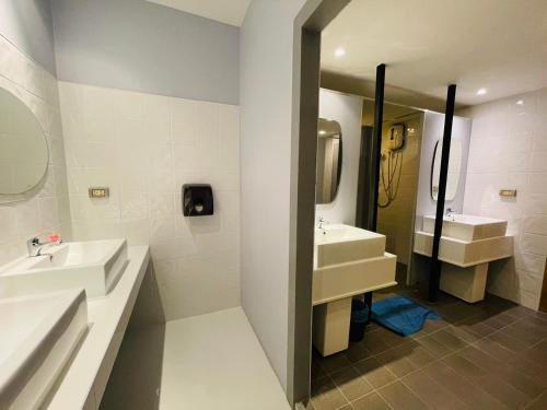 a white bathroom with two sinks and a mirror at Rabbitel Phuket in Phuket