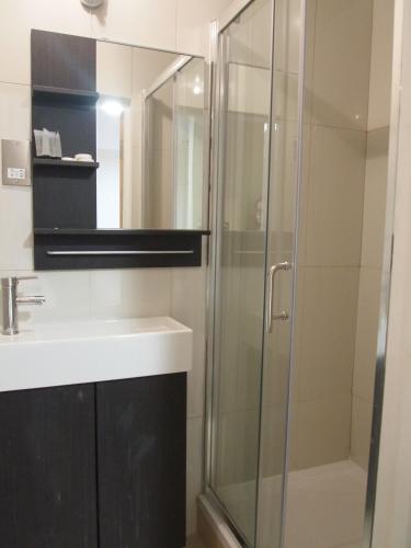 a bathroom with a shower and a sink at Earls Court Garden Hotel in London