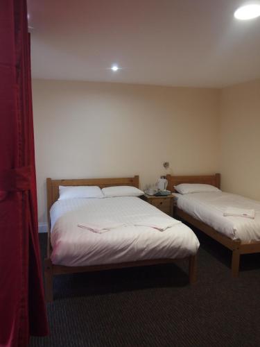 a room with two beds in a hotel room at Earls Court Garden Hotel in London