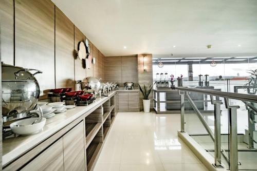 een grote keuken met een aanrecht met borden erop bij Sunrise Aventus Hotel Nusa Dua in Nusa Dua