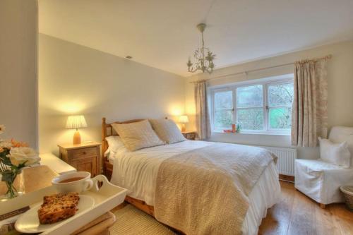 um quarto com uma cama com uma bandeja de comida em River Cottage Brecon: Hot Tub, Fire, Balcony, Wifi em Brecon
