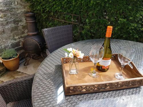 a bottle of wine and glasses on a tray on a table at River Cottage Brecon: Hot Tub, Fire, Balcony, Wifi in Brecon