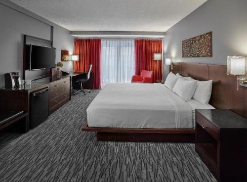 Habitación de hotel con cama, escritorio y TV. en Matrix Hotel, en Edmonton