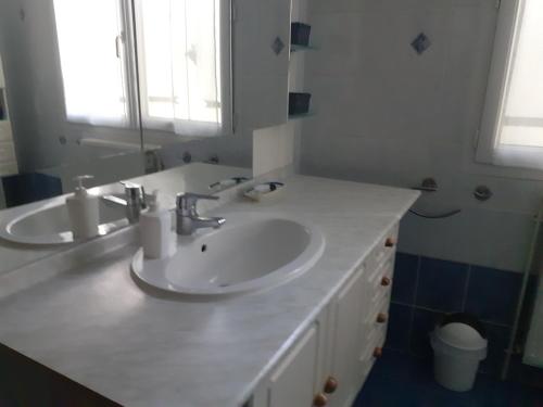ein weißes Badezimmer mit 2 Waschbecken und einem Spiegel in der Unterkunft La maison d'Augusta in Saint-Martin-de-Coux
