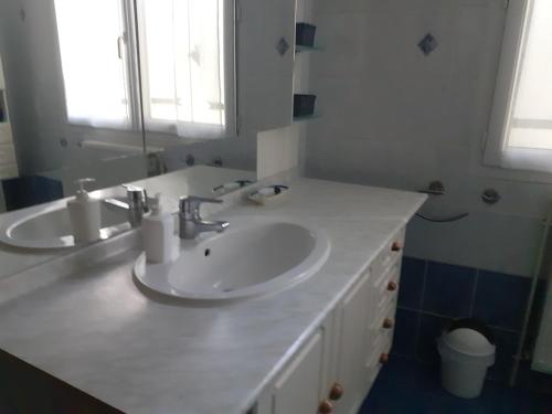 a white bathroom with two sinks and a mirror at La maison d'Augusta in Saint-Martin-de-Coux