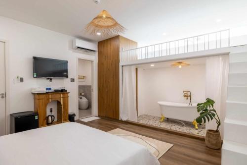 een slaapkamer met een bed en een bad bij Pisces Hotel Hue in Hue