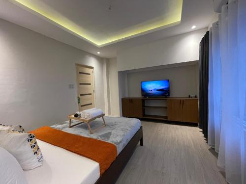 um quarto com uma cama e uma televisão de ecrã plano em Puerto Galera Seascape by Aussie Staycation em Puerto Galera