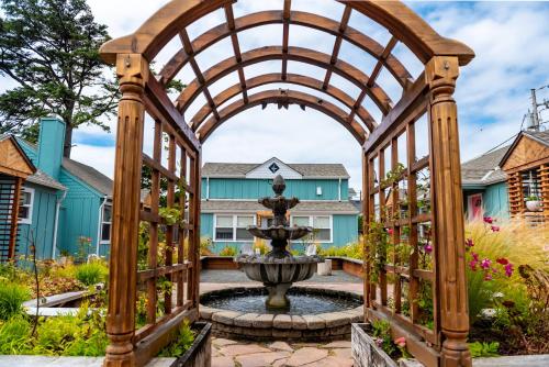 an archway with a fountain in a garden at Inn at Haystack Rock in Cannon Beach