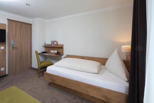 a hotel room with a bed and a desk at Landhotel Sonnenhalde in Bad Boll