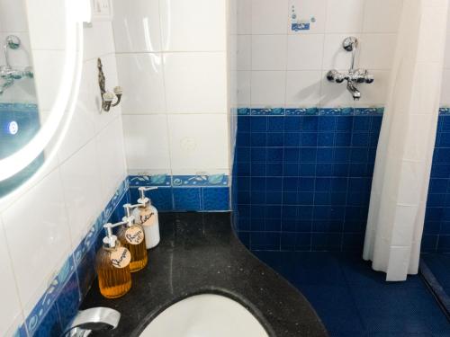 a blue and white bathroom with a toilet and a shower at Casa Do Leão A 150 year Old Portuguese Home in Nerul