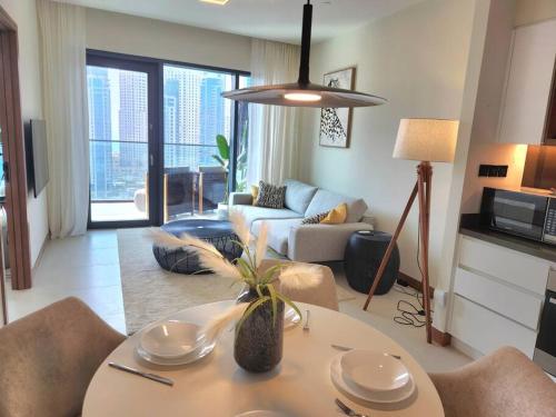 - un salon avec une table et un canapé dans l'établissement Vida Dubai Marina & Yacht Club, 1 BR with Marina and Sea View, à Dubaï