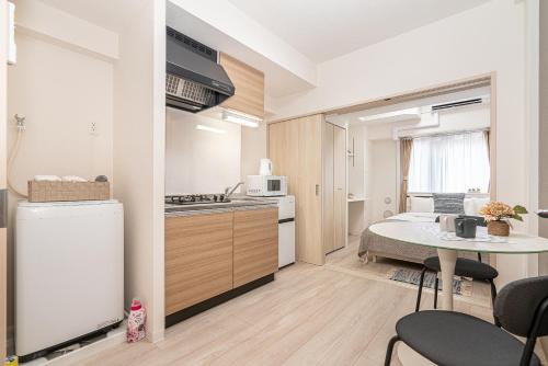 a small kitchen with a table and a small kitchen with a refrigerator at ZAITO Kikukawa SRS Apartment 新築マンション in Tokyo