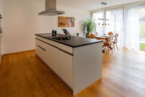 a white kitchen with a sink and a table at Wohnung Pulverturm in Appenzell