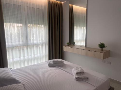 a bedroom with a bed with two towels on it at EME APARTMENTS - Kompleksi San Pietro, Gjiri i Lalzit in Durrës