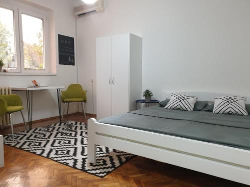 1 dormitorio con 1 cama, mesa y sillas en Apartman Park Jagodina-studio u centru grada en Jagodina
