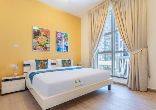 - une chambre avec un grand lit blanc et une grande fenêtre dans l'établissement Two Bedroom Apartment in Dubai Marina Hosted by Desert City Stays, à Dubaï