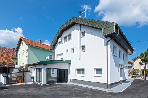 a white building with a green roof at Holiday Home Crux in Krizanec
