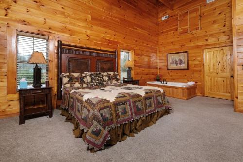 a bedroom with a bed and a tub in a cabin at Hemlock Ridge 1713 in Gatlinburg