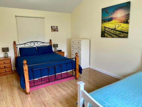 - une chambre avec un lit bleu et une commode dans l'établissement Ronald's Roost farmstay Kangaroo Island, à Wisanger