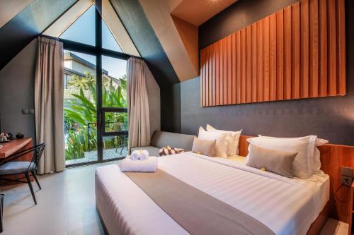 a bedroom with a large bed and a window at Le Cielo Resort Umalas by Maviba in Canggu