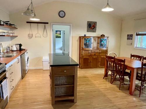 a kitchen with a wooden table and a dining room at Ronald's Roost farmstay Kangaroo Island in Wisanger
